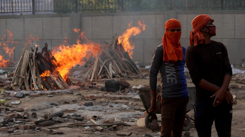 Crematorium workers perform the cremation of a person, who died of Covid-19, at a crematorium in New Delhi