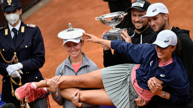 Iga Swiatek poses with members of her team after sweeping aside Karolina Pliskova
