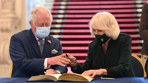 The Prince of Wales and the Duchess of Cornwall sign the visitors' book at Belfast City Hall