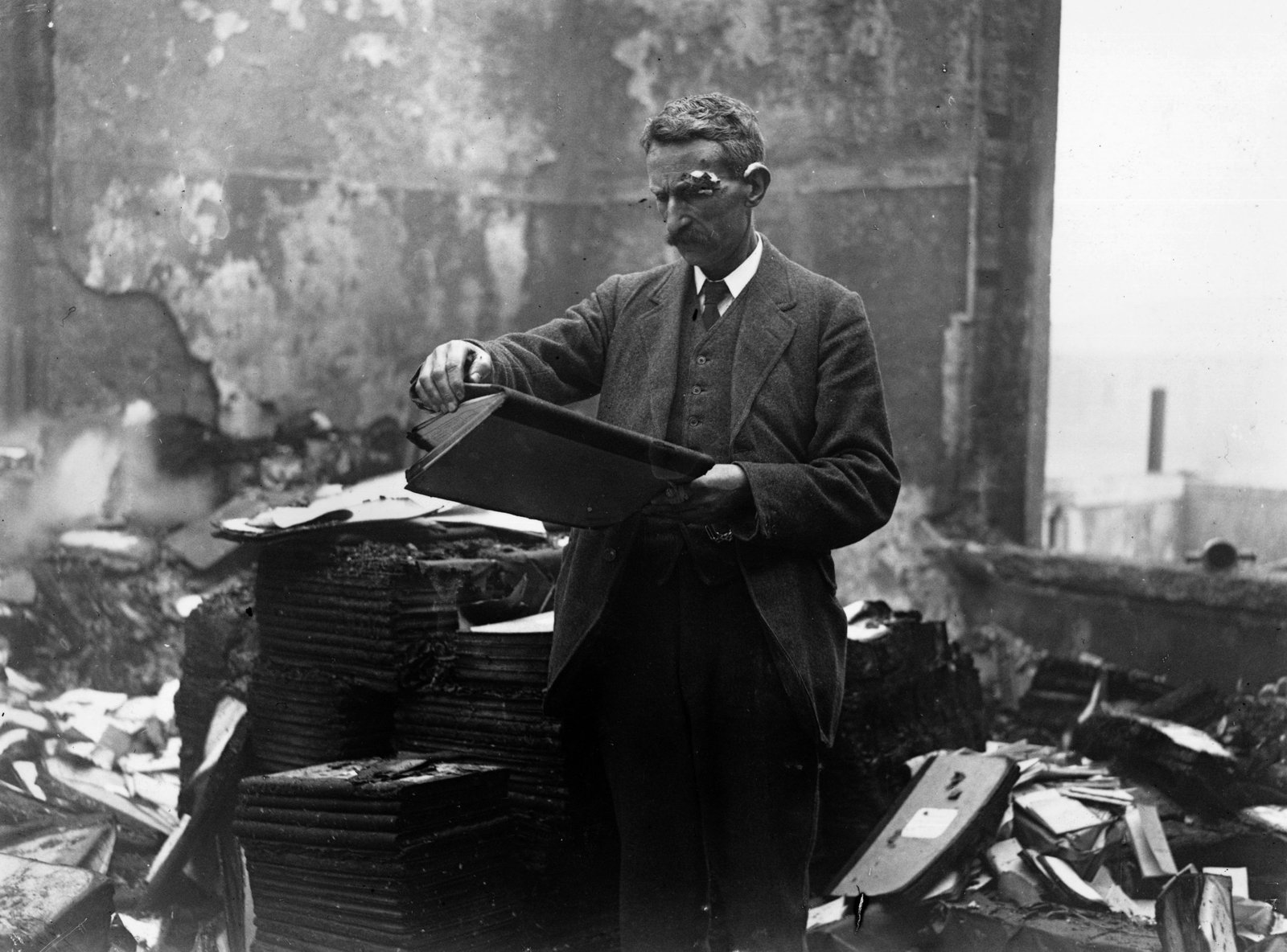 A civil servant retrieves files from the destroyed building. Credit: Getty Images.
