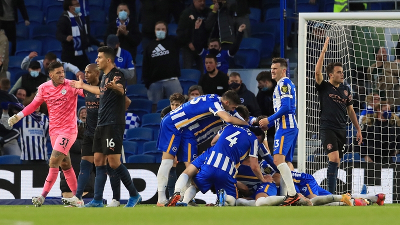 Dan Burn is mobbed by his Brighton team-mates after scoring the winning goal at the Amex