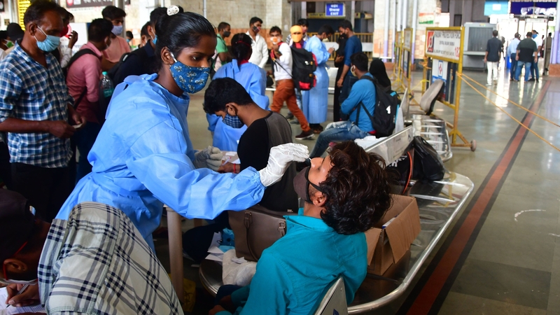 Healthcare workers collect nasal samples from passengers at CSMT station in Mumbai, India
