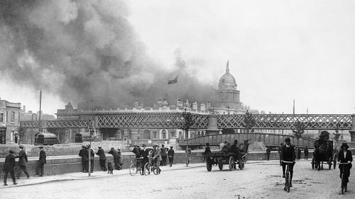 Dubliners watch on from across the Liffey as the Custom House burns after the IRA attack in May 1921. Photo: Bettmann/Getty Images