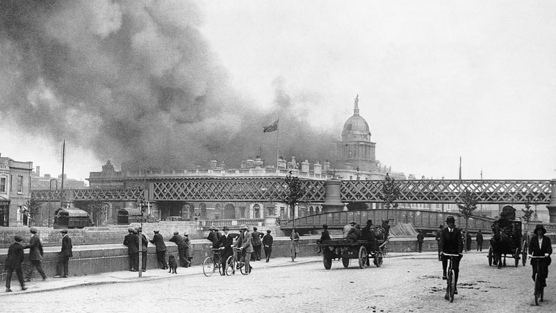 Dubliners watch on from across the Liffey as the Custom House burns after the IRA attack in May 1921. Photo: Bettmann/Getty Images