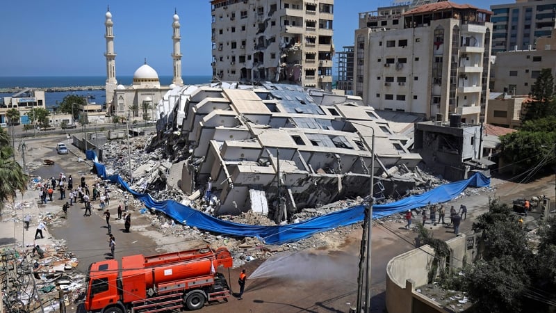 Palestinian volunteers clear the rubble of buildings destroyed by air strikes in Gaza city