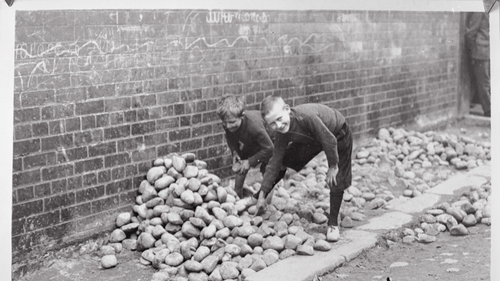 Children gather stones on the streets of Belfast, circa 1920. Photo: Getty Images