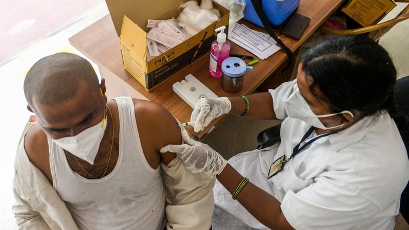 A health worker vaccinates a man with a dose of the Covid vaccine during a vaccination drive for auto-rickshaw and taxi drivers at a school in Hyderabad