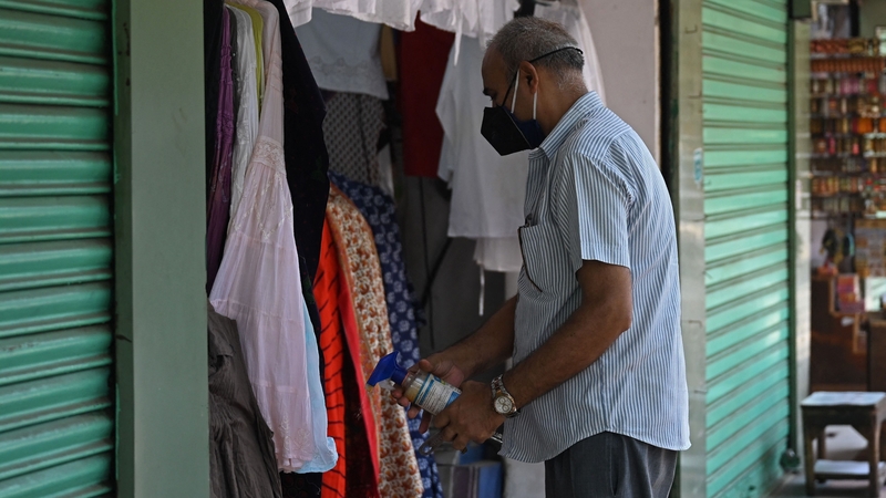 A shopkeeper in New Delhi gets ready to reopen his store