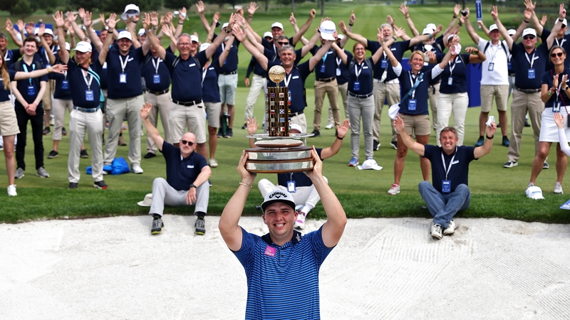Marcus Armitage poses with the trophy and tournament volunteers after winning the Porsche European Open