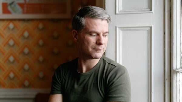 Cian Ó Cíobháin, dár stiúradh thar táirseach an cheoil.