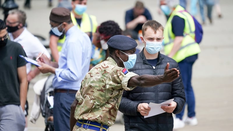 Soldiers from the Royal Horse Artillery guide members of the public at a rapid vaccination centre in Bolton