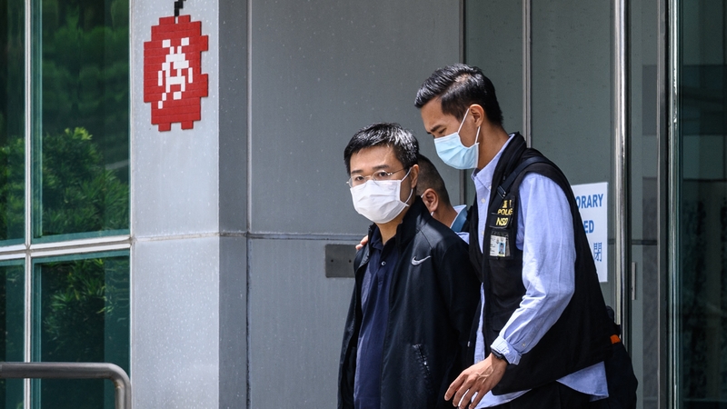 Apple Daily editor Ryan Law being escorted by Hong Kong police from the newspaper's office