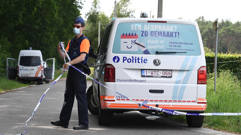 A Belgian policeman cordons off the scene