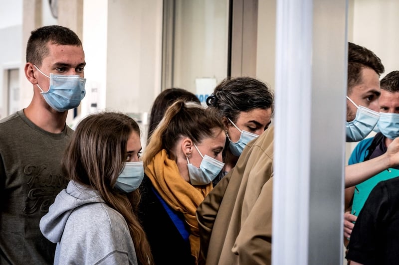Valerie Bacot (yellow scarf) arrives flanked by her children to the Chalon-sur-Saone Courthouse, central-eastern France, prior to the opening hearing of her trial on charges of murdering her stepfather turned husband