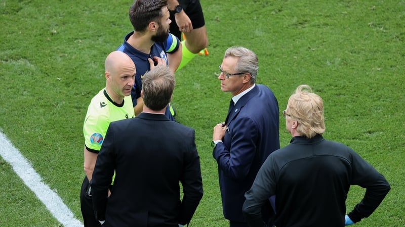 Anthony Taylor interacts with Denmark manager Kasper Hjulmand and his Finnish counterpart Markku Kanerva following the treatment to Christian Eriksen