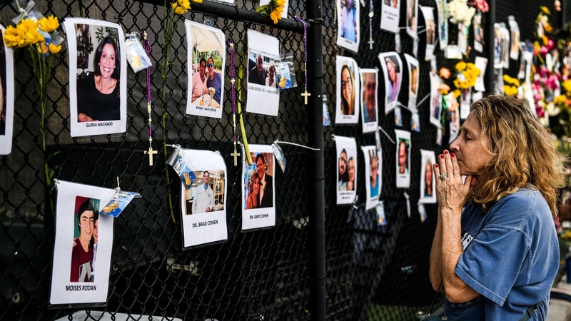 A woman prays at the scene while search and rescue teams continue to look for survivors