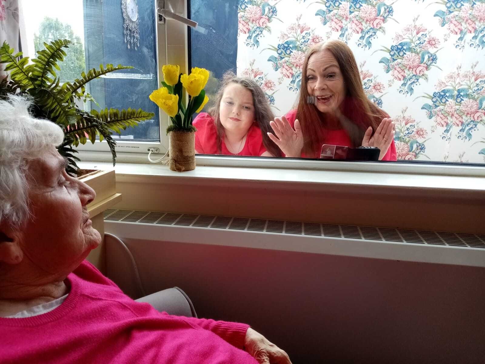 Christine Thompson and her daughter, Sarah, enjoy a precious window visit with her mother, Kathleen