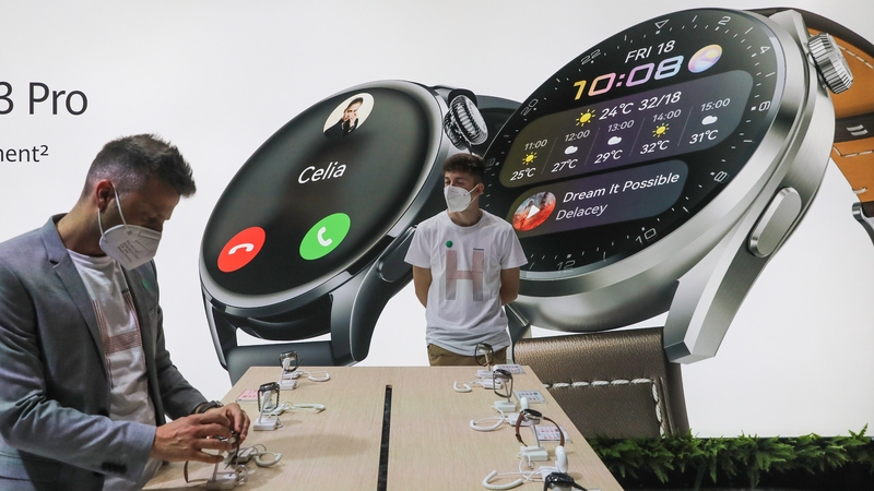 An attendee inspects Huawei smartwatches on the Huawei stand at the MWC in Barcelona