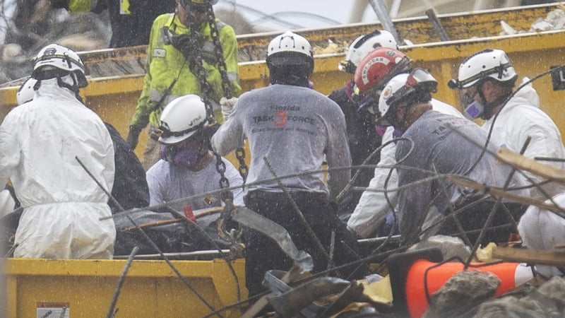 A body is removed on a stretcher from the rubble of the Champlain Towers South condominium