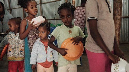 Children, who fled the violence in Ethiopia's, Tigray region, wait in line for