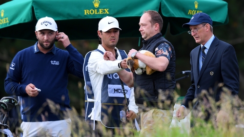 A spectator is removed after appearing to take Rory McIlroy's driver headcover