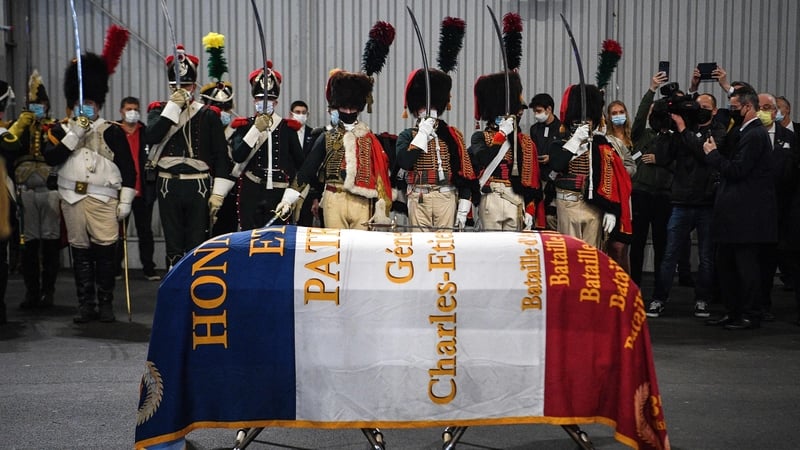 Men dressed as Napoleon-era fighters stand in respect beside a coffin containing the remains of Charles Etienne Gudin in Paris today