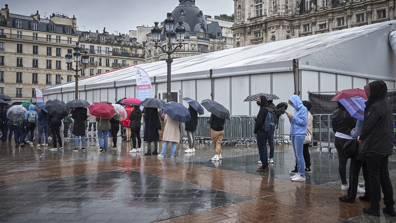 People queue in the rain to be vaccinated at Hotel de Ville in Paris today