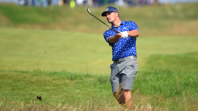 DeChambeau plays from the rough on the 18th hole during a practice round