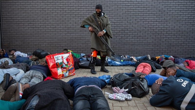 A policeman guards a group of suspected looters