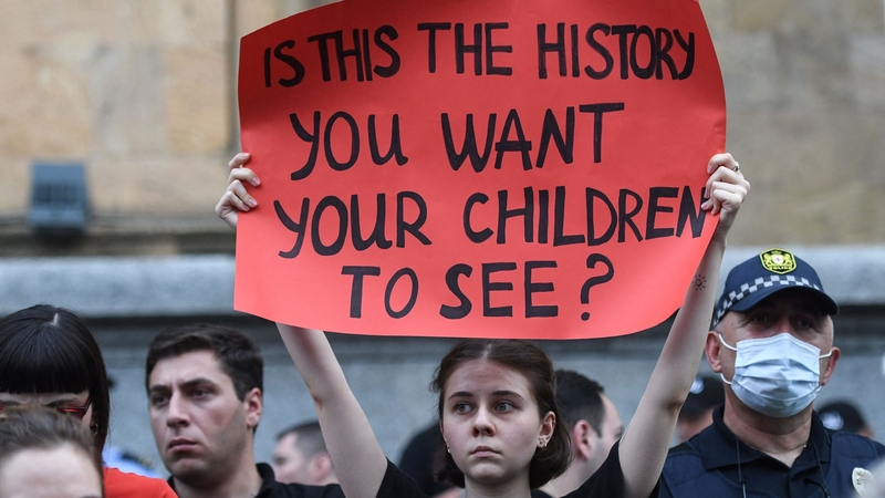 A woman holds up a placard during a rally in Tbilisi