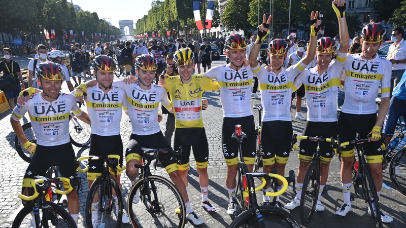 Tadej Pogacar celebrates on the Champs Elysees with his UAE Team Emirates colleagues