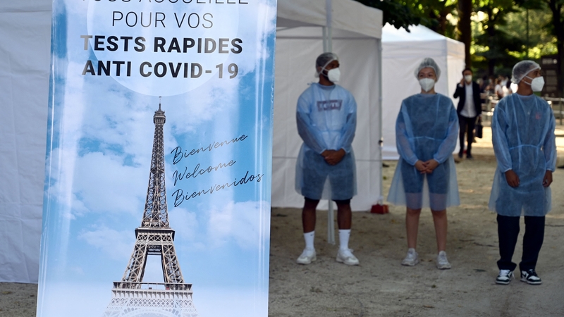 Health workers stands near an antigenic test area outside the Eiffel Tower
