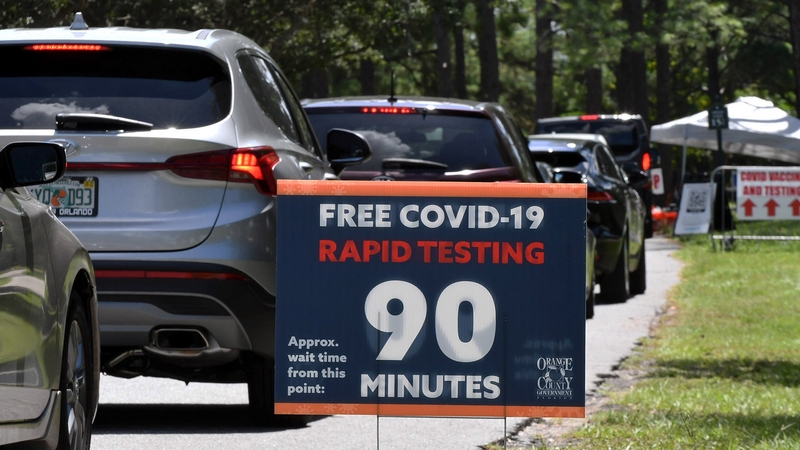 People in cars wait at a Covid-19 testing and vaccination site at Barnett Park, Orlando, Florida