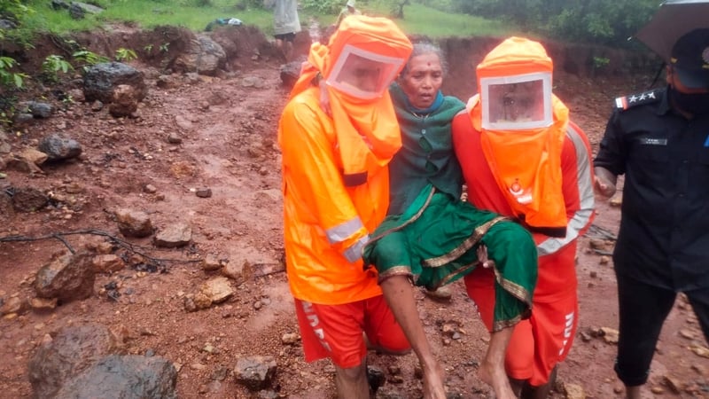 National Disaster Response Force rescuers carry a woman to safety in Maharashtra state