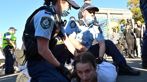 Police officers detain a protestor during a rally in Sydney