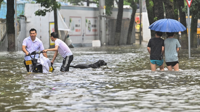 People wade in a flooded street in Ningbo in eastern China's Zhejiang province today