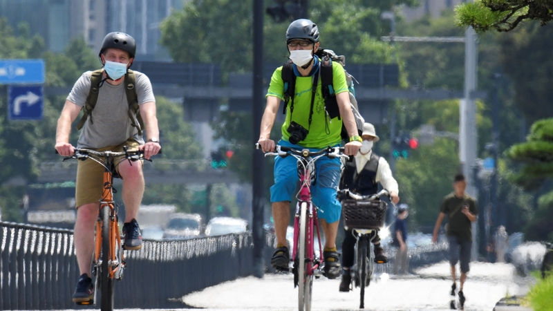 People ride bicycles near the Imperial Palace