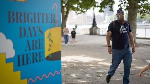 A pedestrian walks past a coraonvirus sign in London