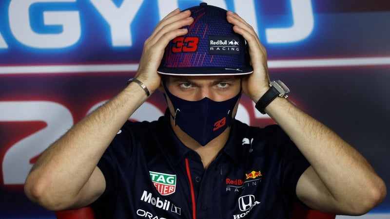Verstappen adjusts his cap as he addresses a press conference at the Hungaroring