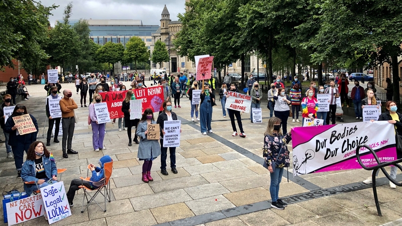 People hold up placards and banners as they take part in a pro-choice rally in Belfast's Writer's Square