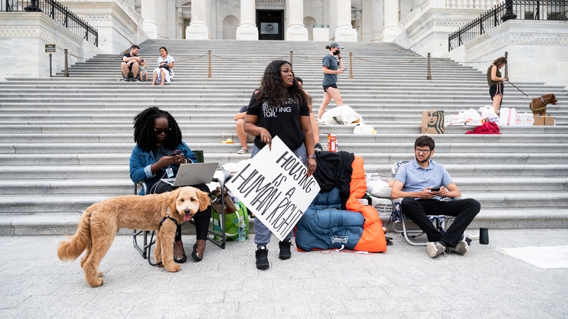 Rep. Cori Bush holds a 'housing is a human right' sign outside the US Capitol
