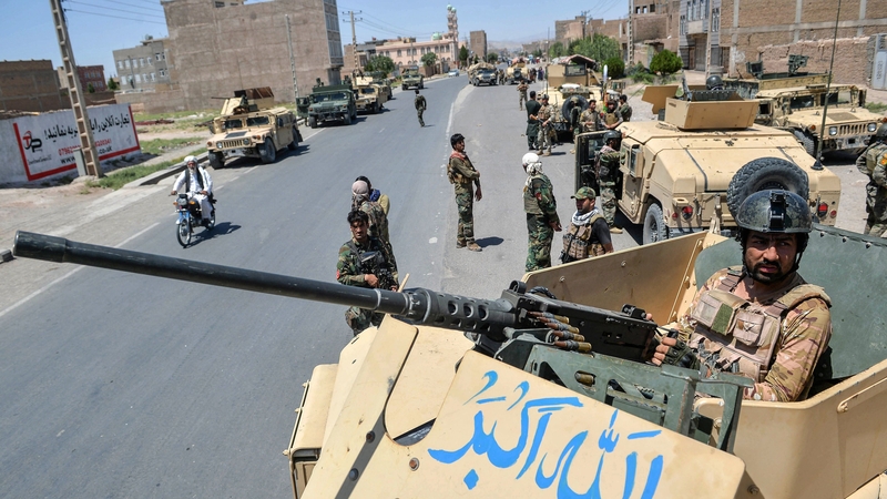 An Afghan army commando stands guard on top of a military vehicle in Enjil district, Herat province, today