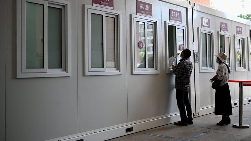 A medical worker takes a swab sample from a man in Beijing