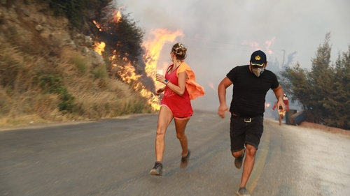 People run away from the fire as ground and aerial extinguishing operations continue in Mugla, Turkey