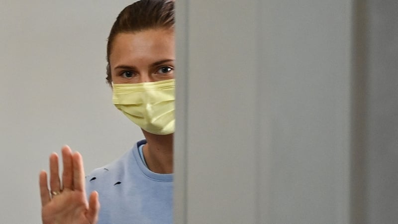 Krystsina Tsimanouskaya waves goodbye as she boards her Vienna-bound flight at Narita International Airport in Japan