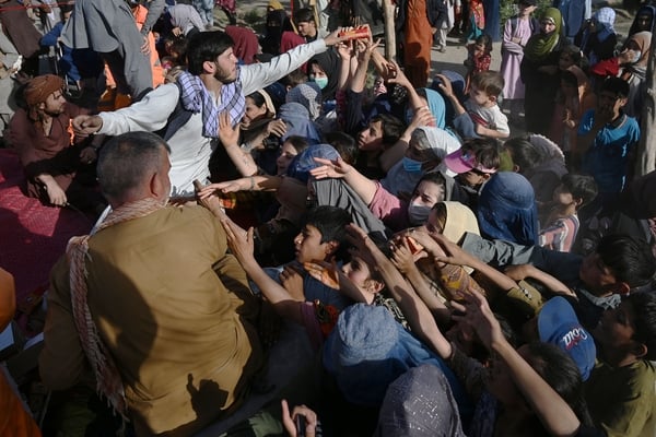 Internally displaced Afghan families scramble for food packages, pic: Getty