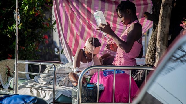 A boy is tended to outside Les Cayes General Hospital after a 7.2-magnitude earthquake