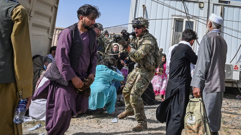 A US soldier points his gun towards an Afghan civilian at the Kabul airport today