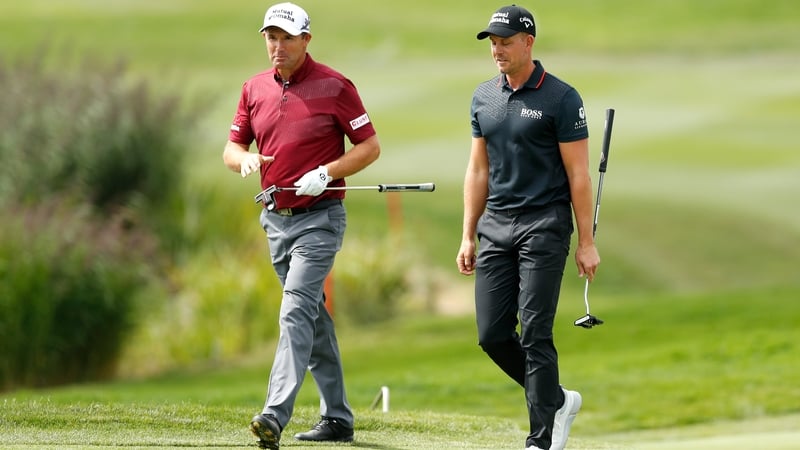 Padraig Harrington speaks with Henrik Stenson on route to the ninth hole
