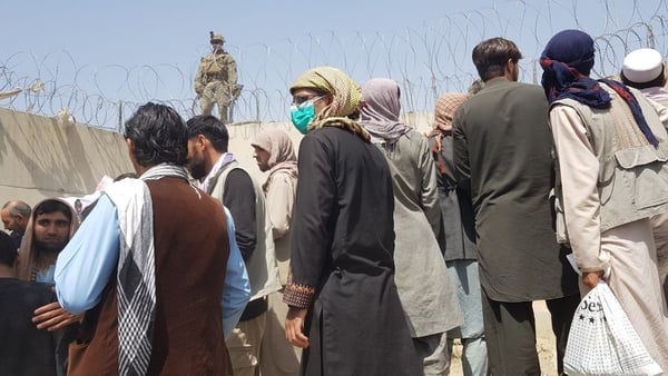People trying to leave Afghanistan wait near Kabul airport